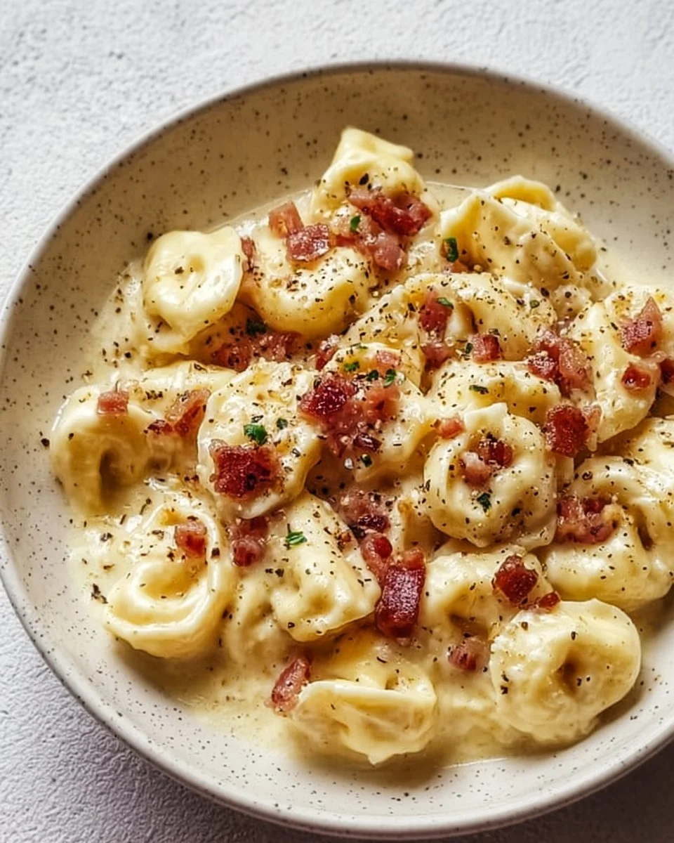 Creamy Tortellini Carbonara topped with crispy bacon and Parmesan cheese